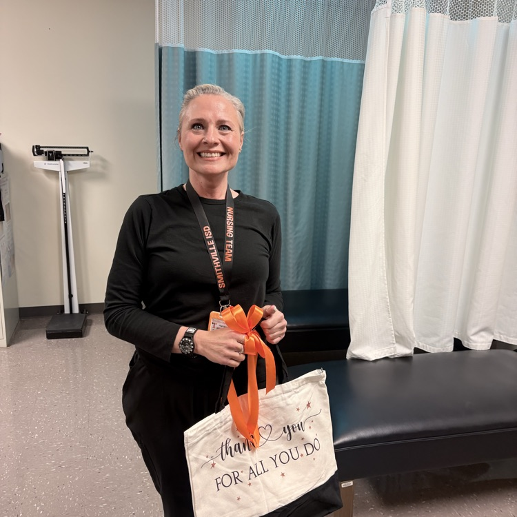 a woman holds up a black and white bag