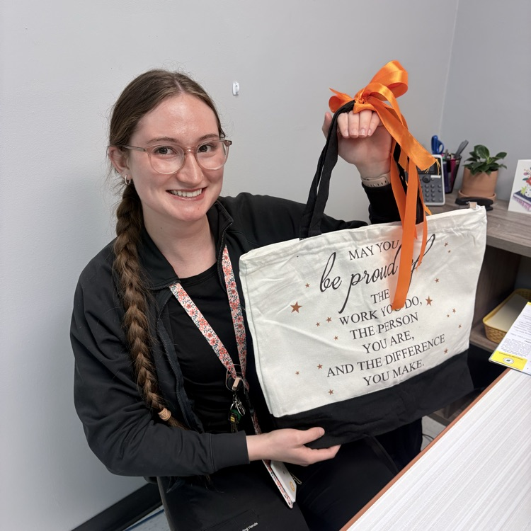 a woman holds up a black and white bag