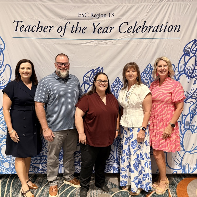 people standing in front of teacher of the year banner