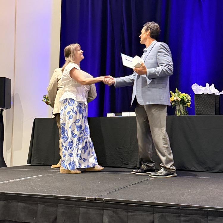 woman shakes hands with a man on stage