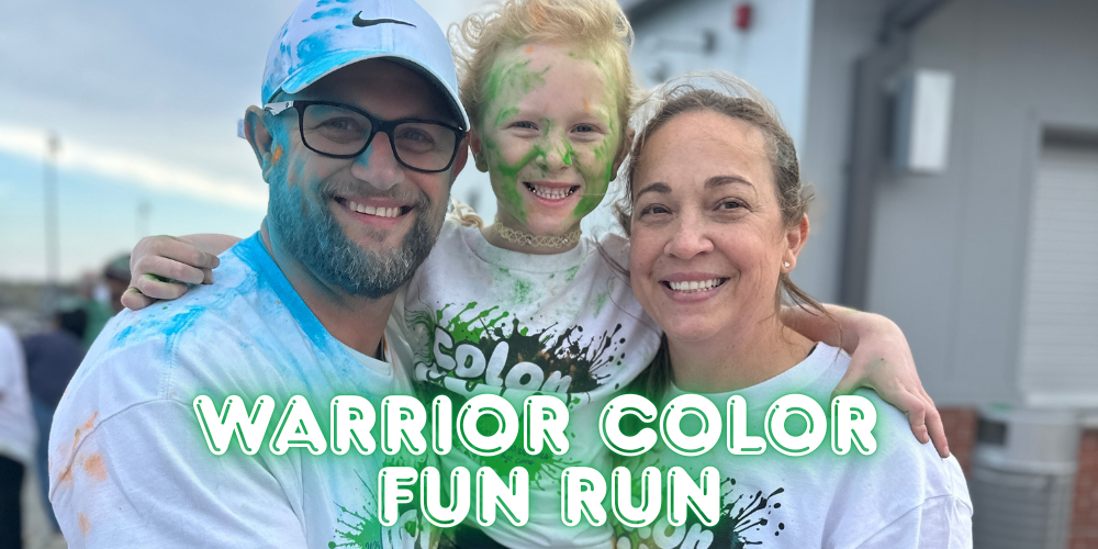 A family smiling at the camera after getting covered in colored powder during the color run