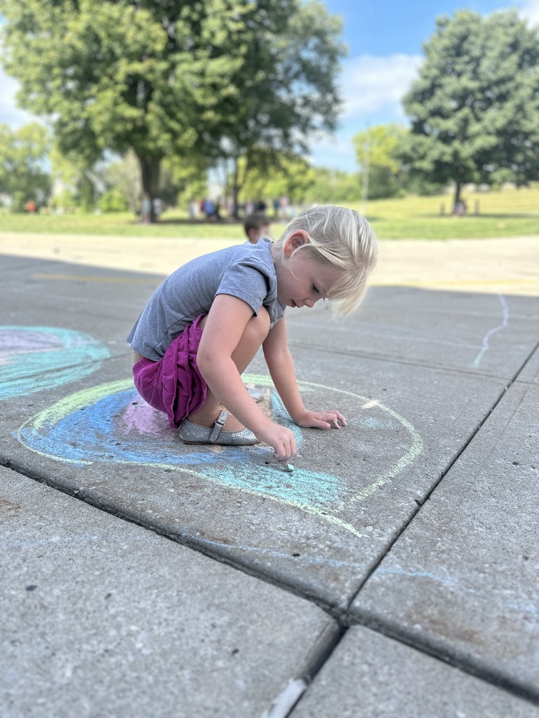A little girl drawing sidewalk chalk