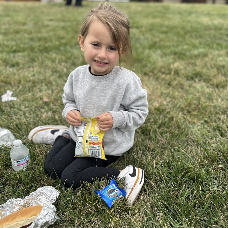 Little girl posing with a bag of chips at the tailgate