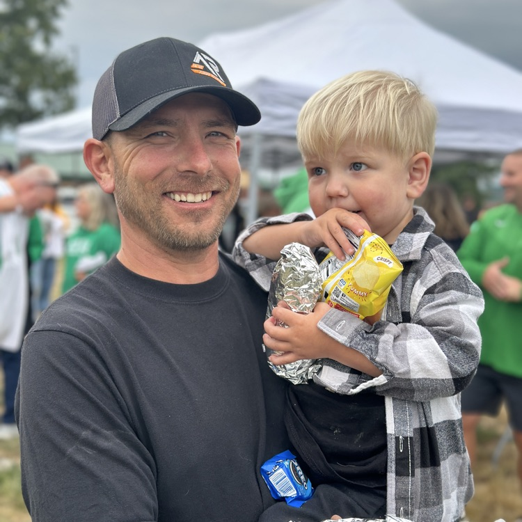 my dad holding his little boy at the tailgate