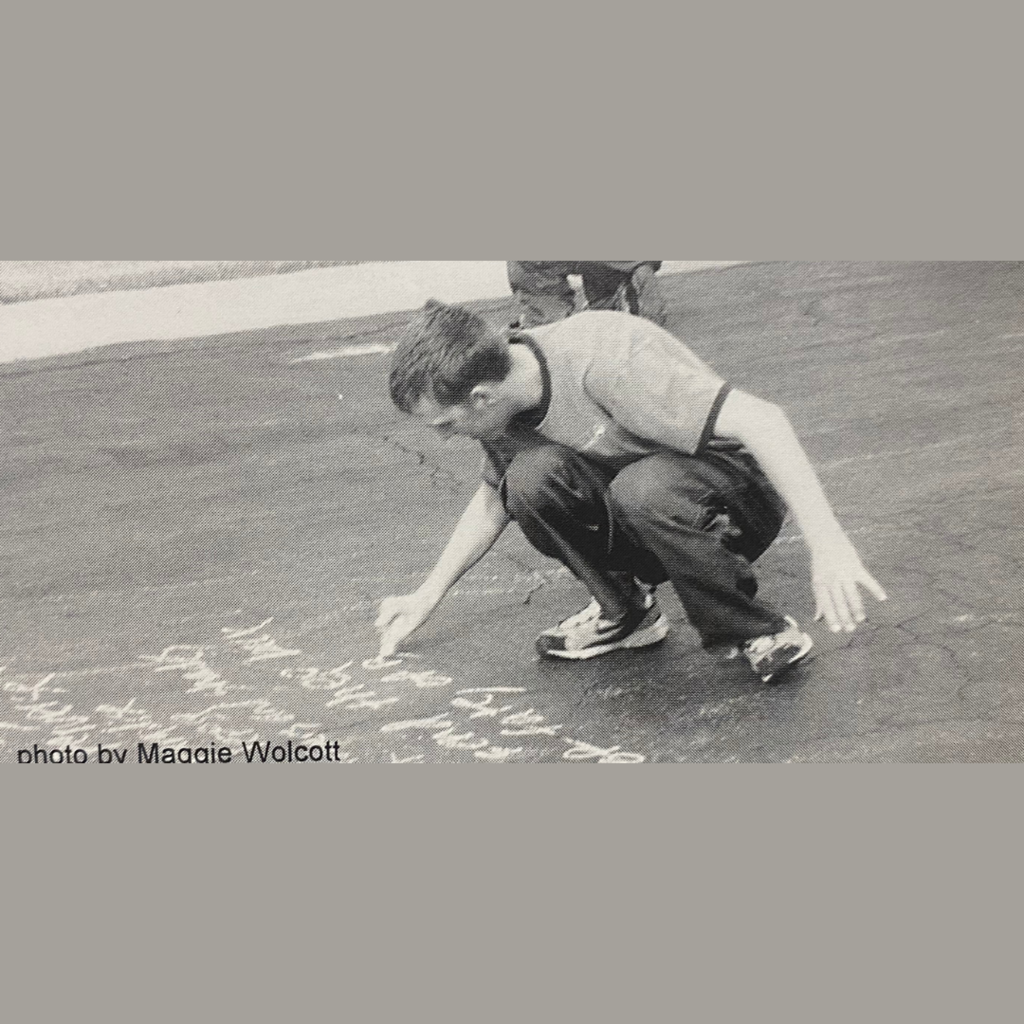 Student writes an excerpt from John Milton's Paradise Lost in the parking lot of the highschool during Understanding Literature.