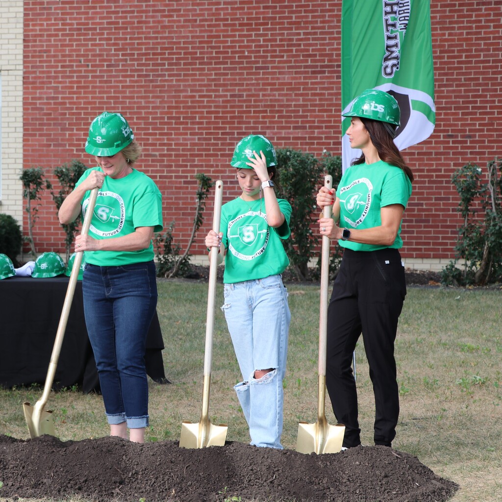 Women standing holding shovels