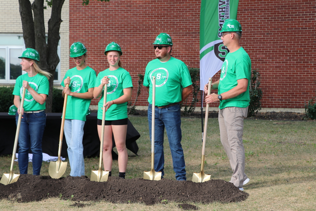 People standing with their shovels preparing to dig