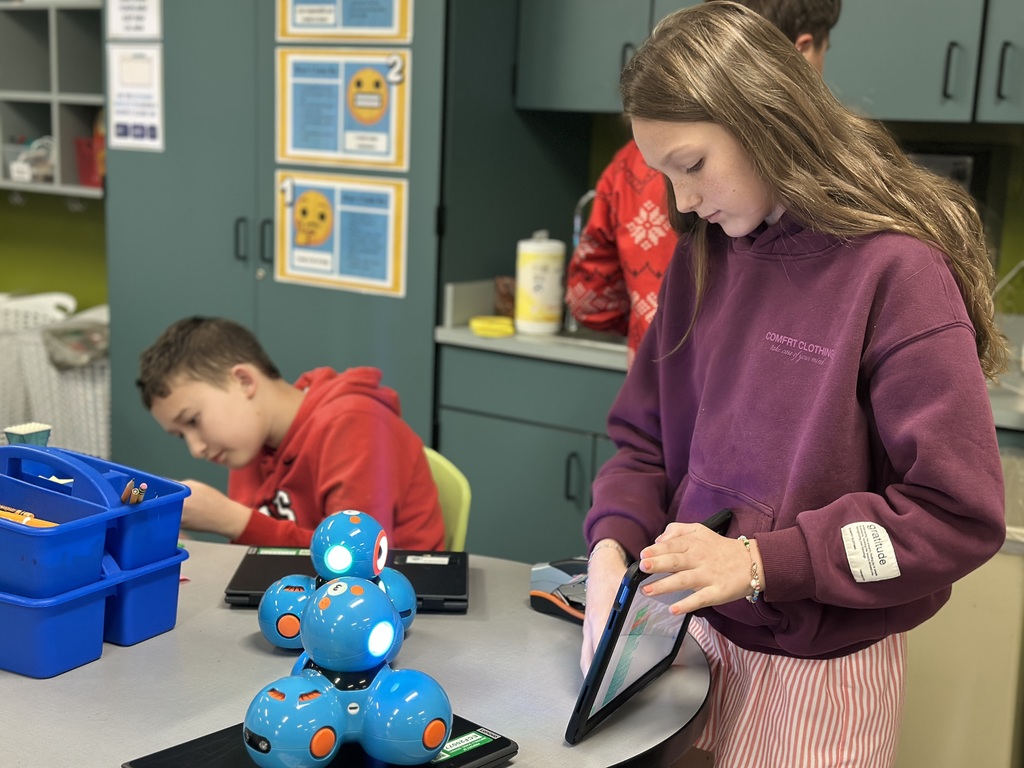 6th Grade student works on tablet to code a robot