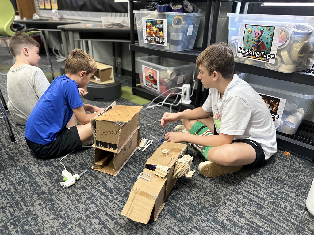 6th Grade student use cardboard and popsicle sticks to build tiny homes