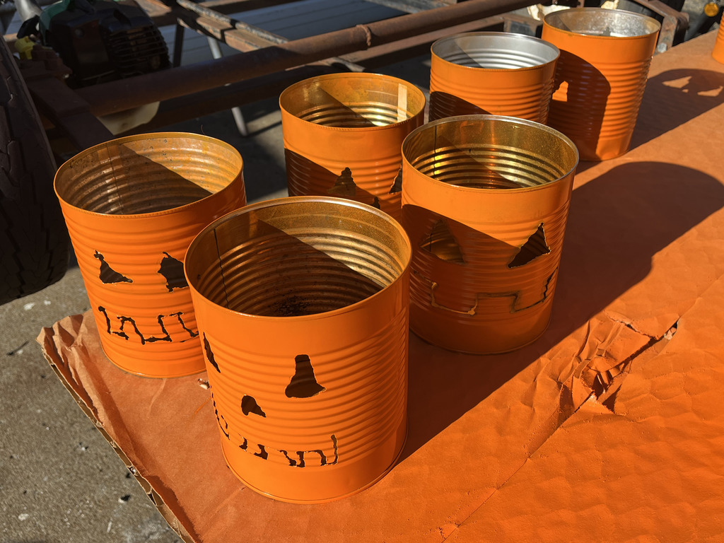 A picture of several tin can jack-o-lanterns after they are complete.