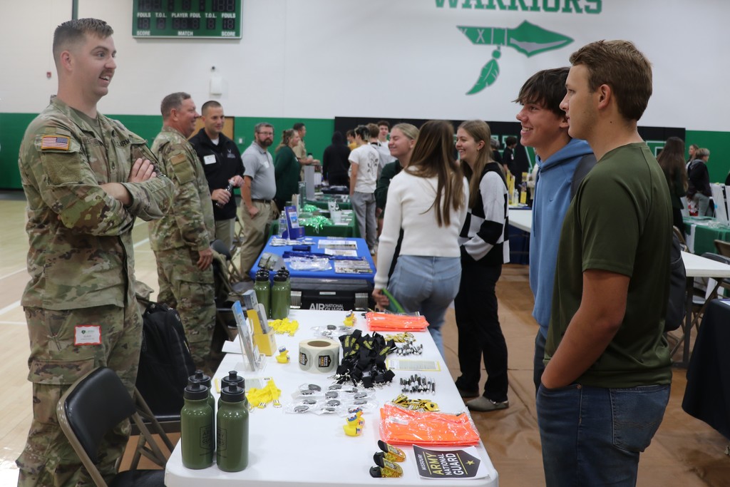 Students speak to a military recruiter at the college and career fair