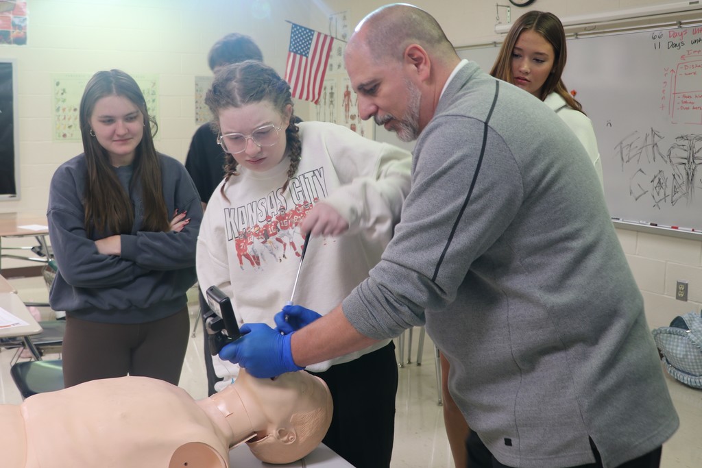A student assists the NRAD presenter intubate a CPR manikin.