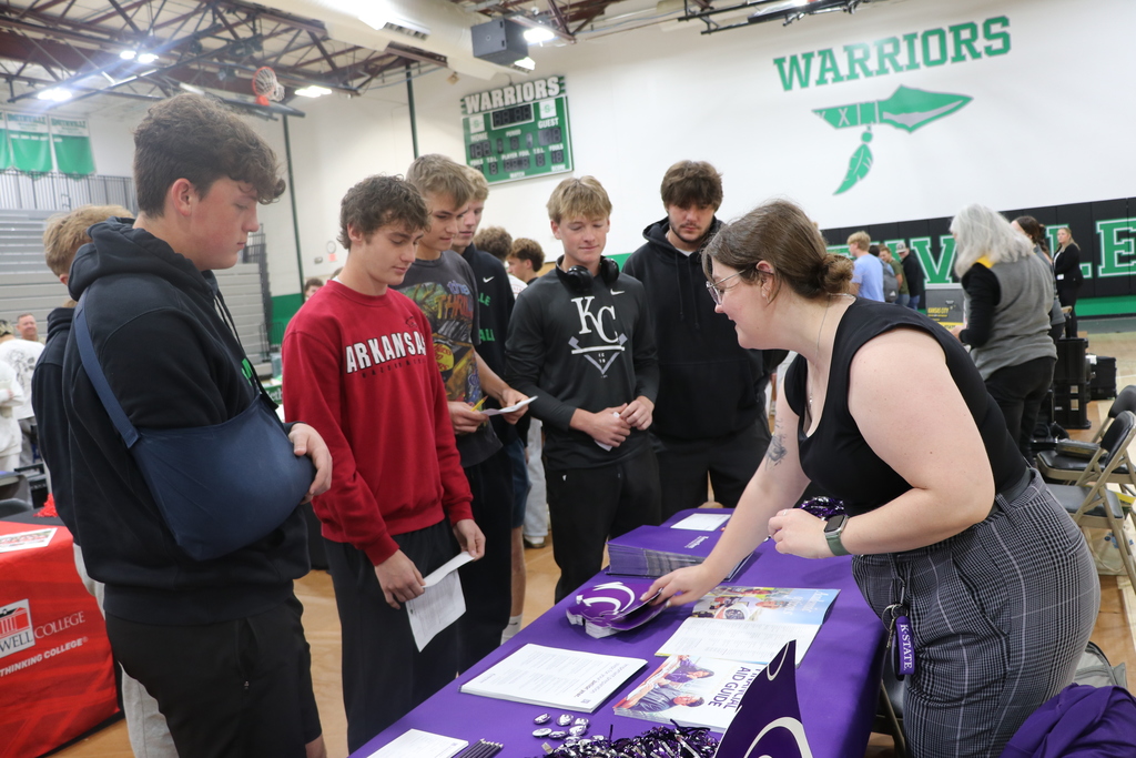 Students speak to a college from K-State recruiter at the college and career fair