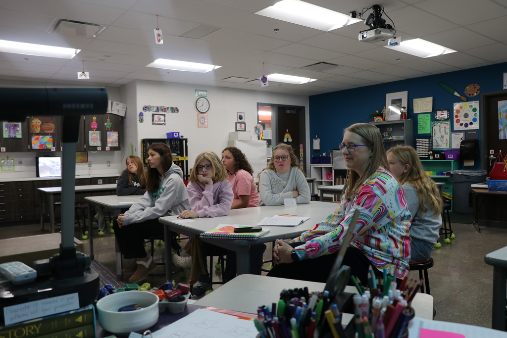 Eagle Heights art teacher and 5th 6th Grade art club students look at a laptop screen as they meet virtually with an artist.
