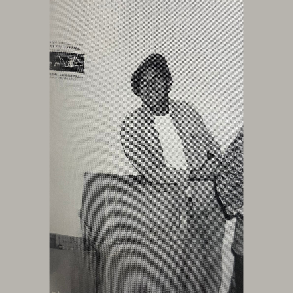 2002, history teacher leaning against a trash can flashing a smile.