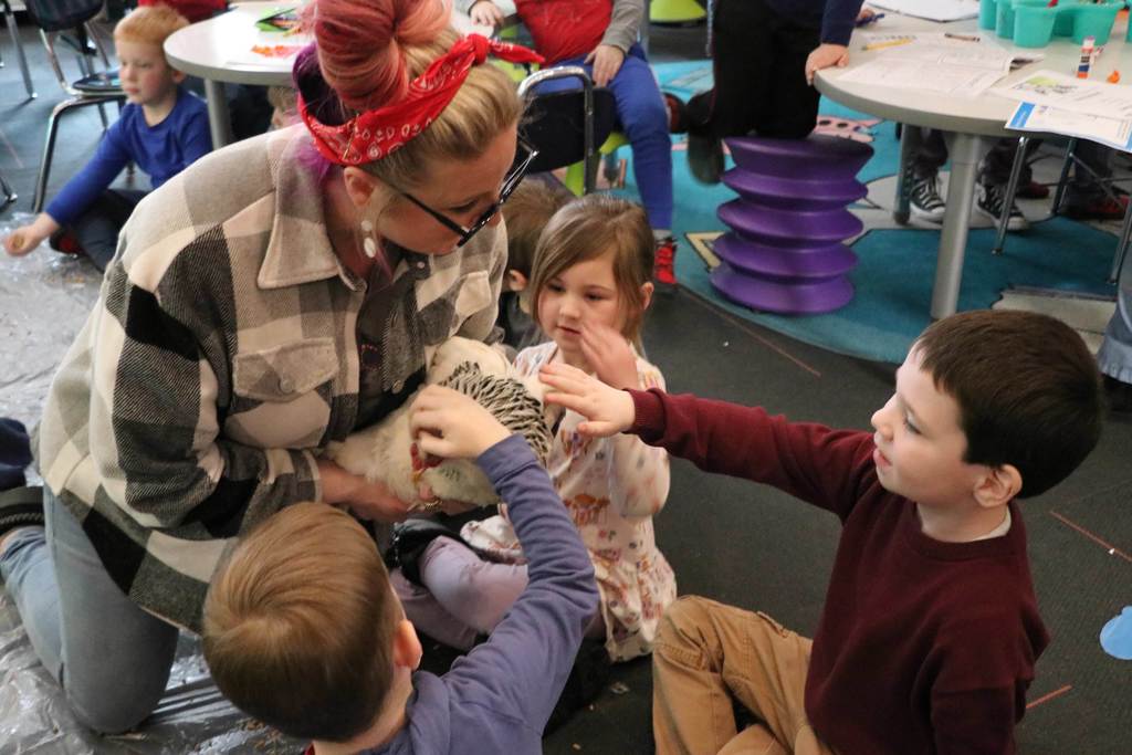 Kindergarteners pet a chicken