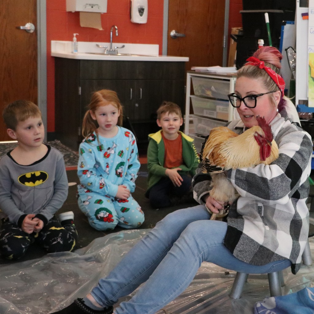 The teacher holds the chicken in her arms