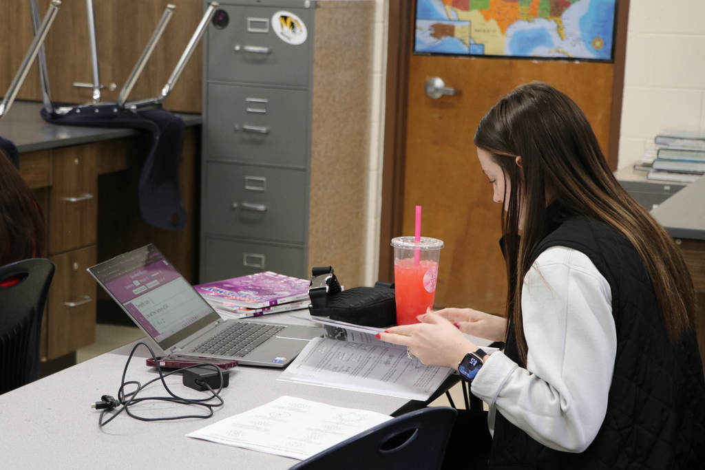 A teacher flips through a book.