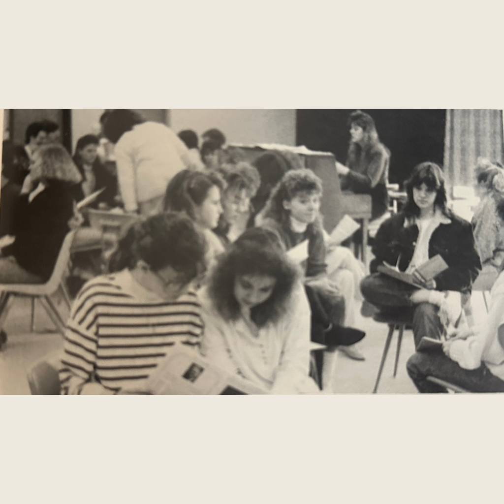 Choir members are in groups warming up before a performance.