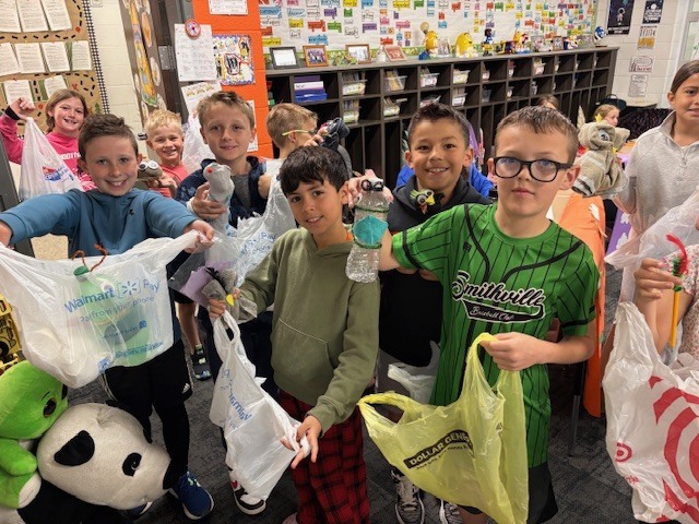 Students show off their bags of goodies they were able to purchase during their economics unit.
