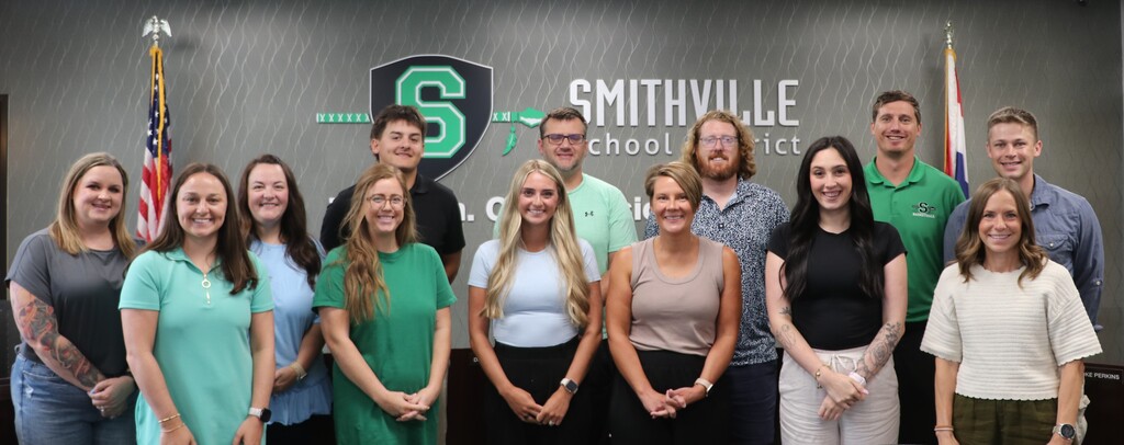 New staff pose for a picture in front of the Smithville School District logo