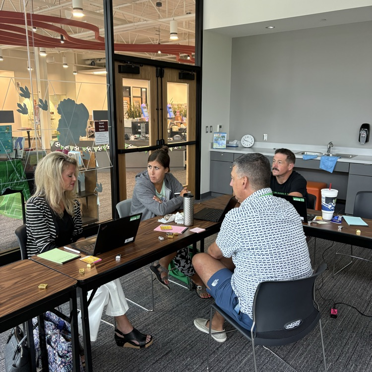 teachers in a small group discussing a topic