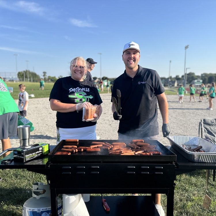 People grilling hotdogs for the community tailgate