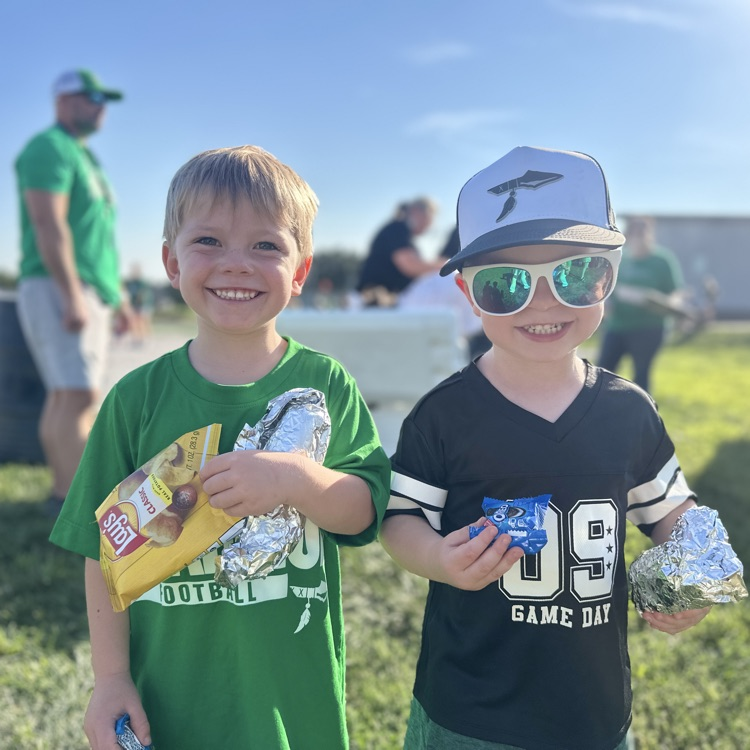 two little boys smiling with their chips and hot dogs