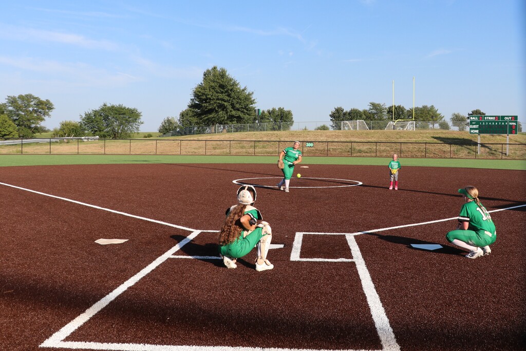 The pitcher representing the present throws her first pitch