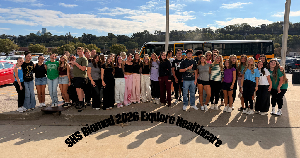 SHS biomedical students pose for a picture with the bus in the background. The picture says "SHS Biomed 2026 Explore Healthcare"