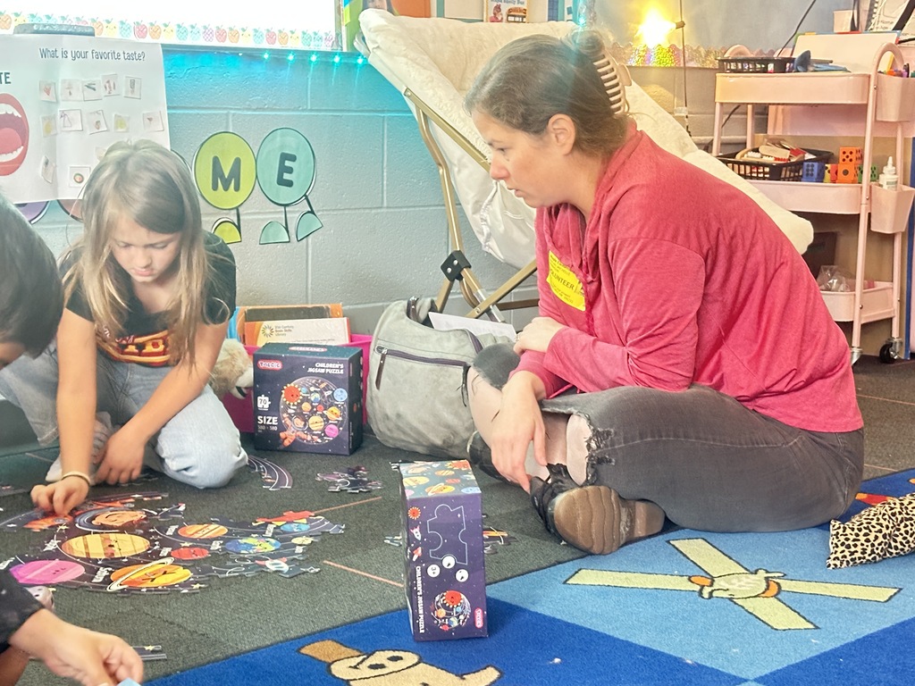 A mentor works on a puzzle with a student