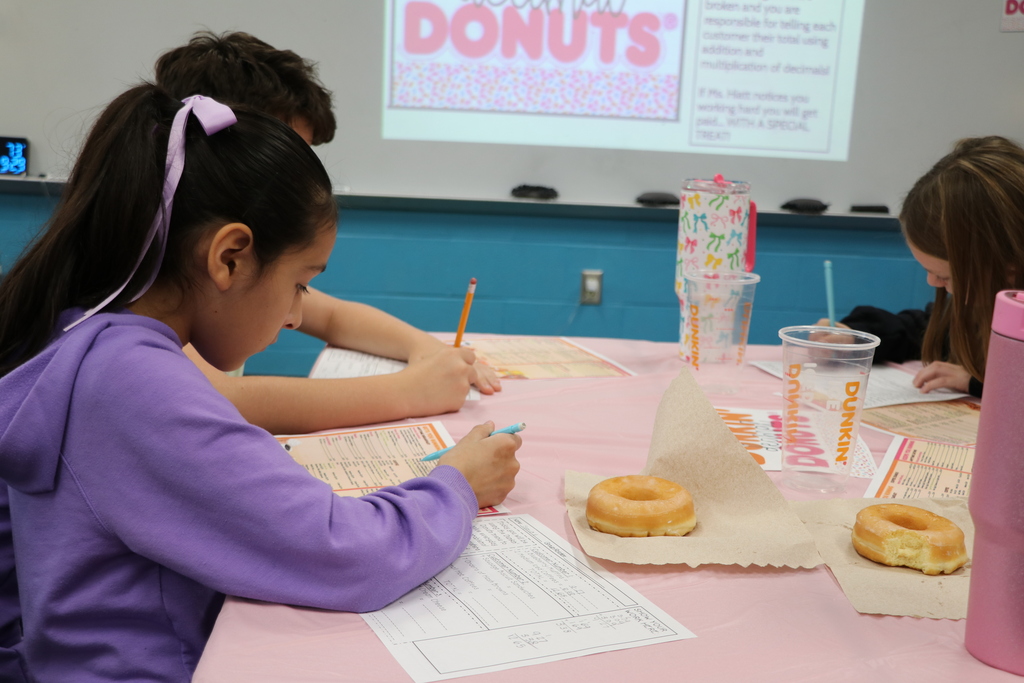 A table of students are working on their worksheets to find the customer's totals.