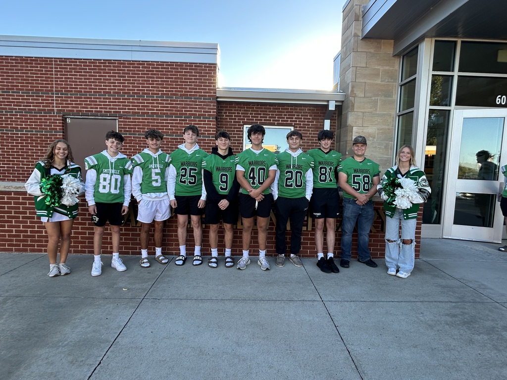 Football players greeting students