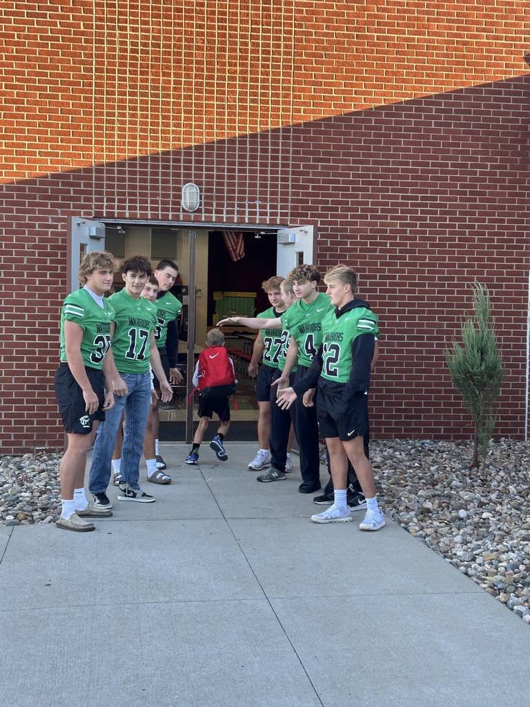 Football players greeting students