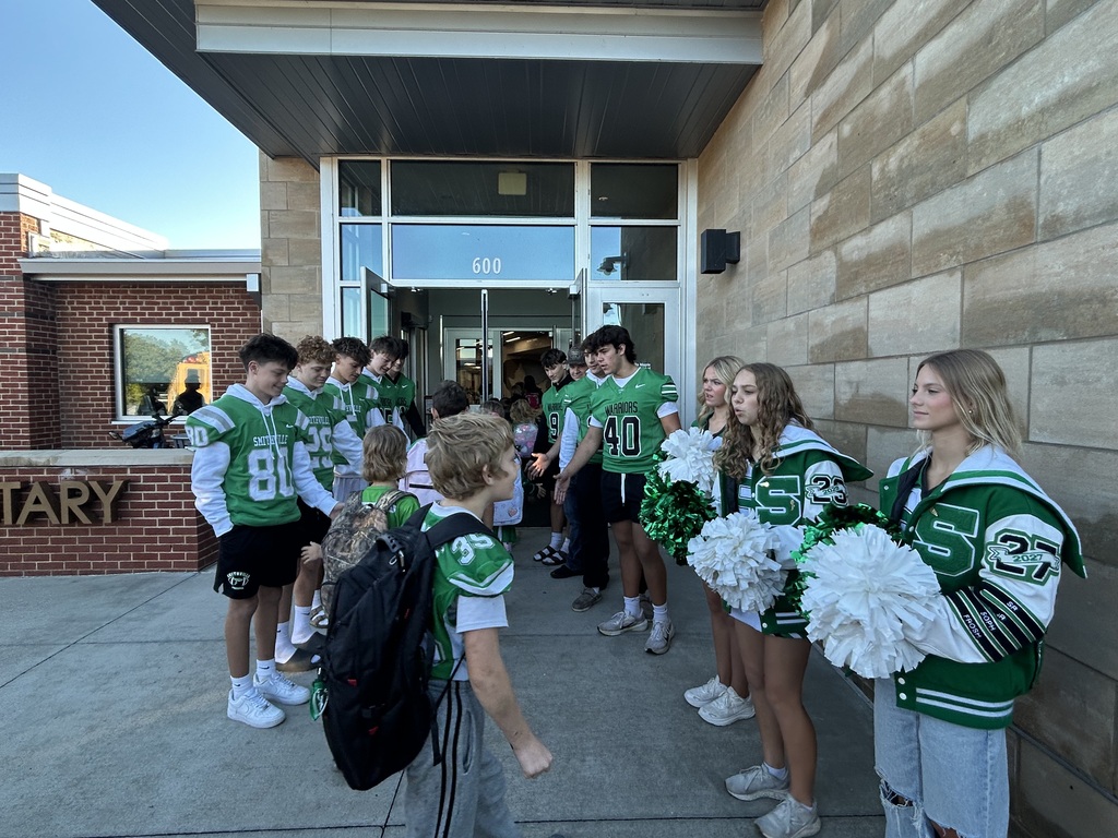 Football players greeting students