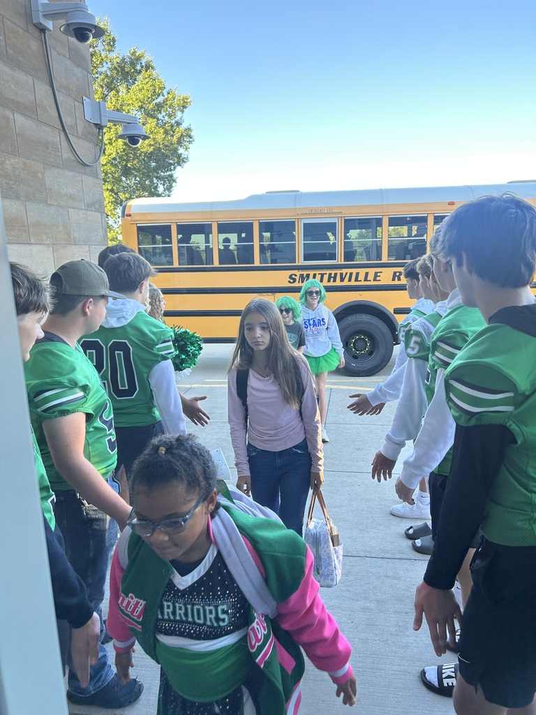 Football players greeting students
