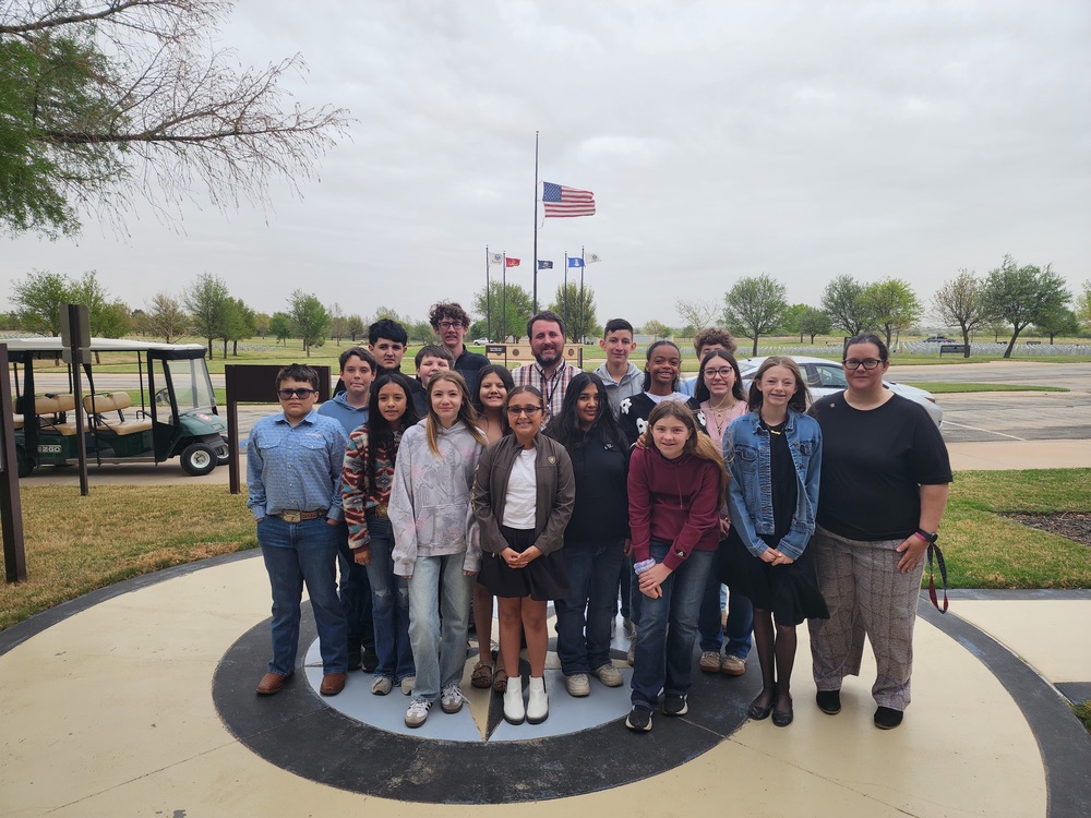 students stading outside cemetery