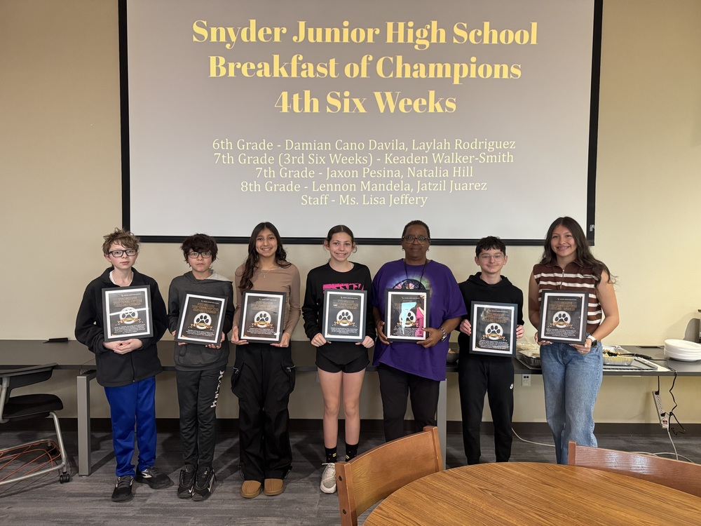 students standing with framed awards