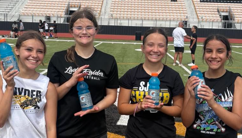 students smiling for photo holding gatorade