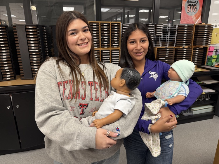student posing with swaddled baby