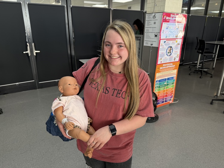student posing with swaddled baby