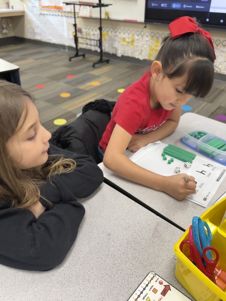 students working on math project together using dice and counting items