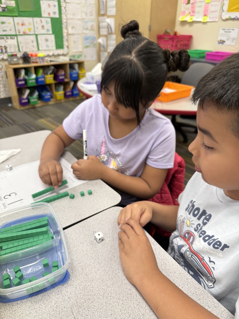 students working on math project together using dice and counting items