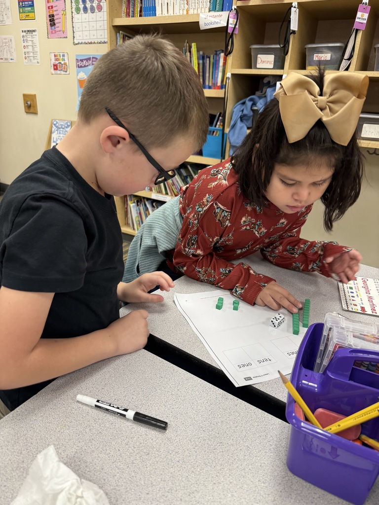 students working on math project together using dice and counting items