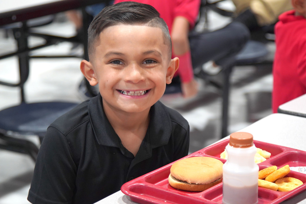 Student smiling with school meal