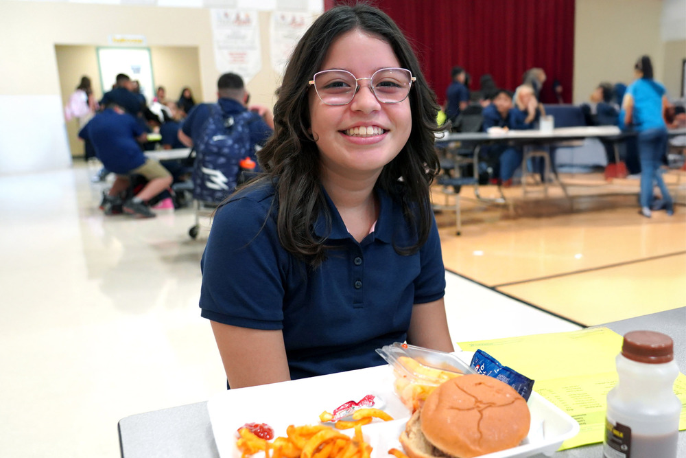 Student with lunch meal smiling