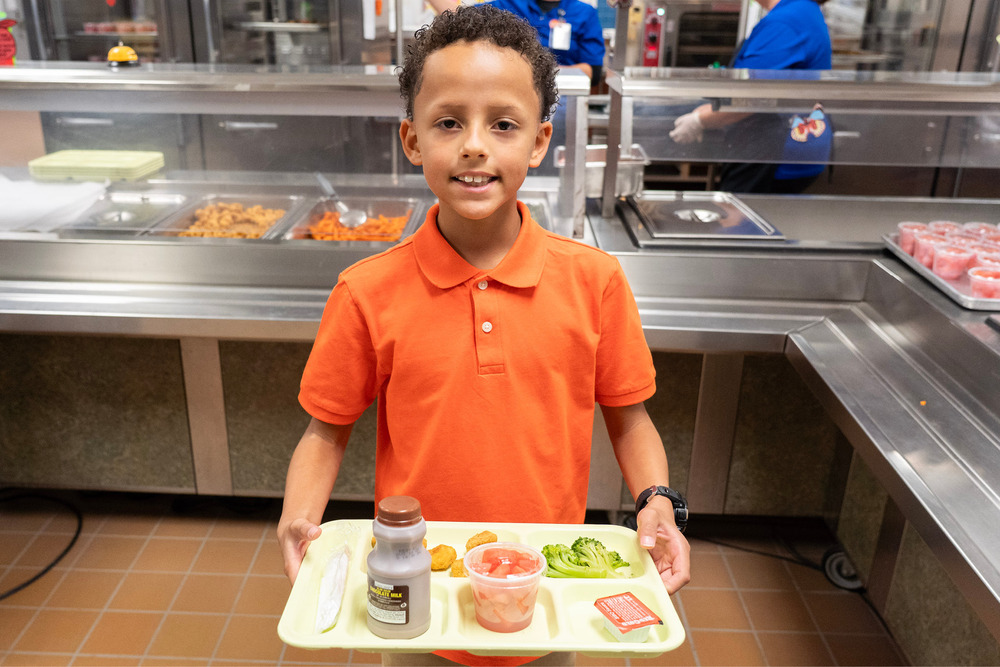Student holding tray with meal
