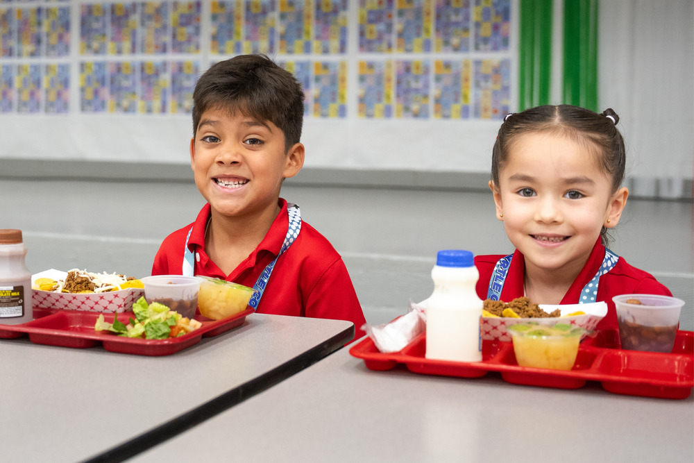 Two students with their school meals