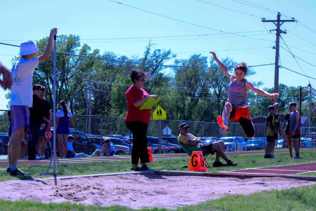 student mid air jumping for long jump