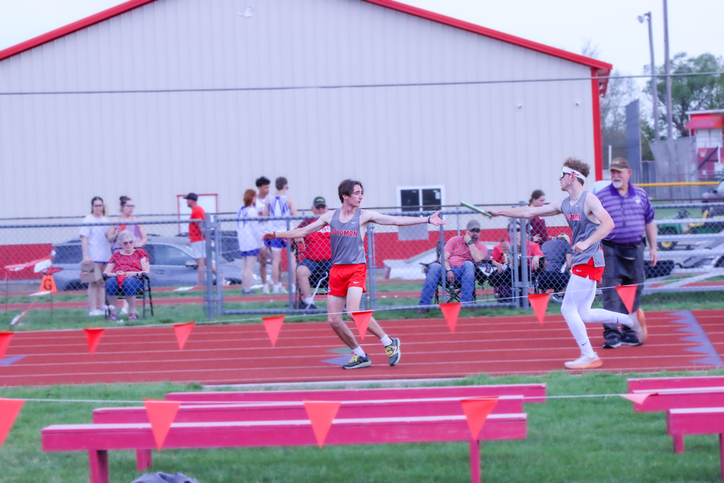 two student mid relay passing the baton